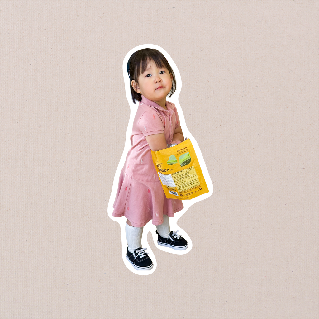 A single full-body cutout sticker of a toddler in a pink dress and black shoes, cut with a white border