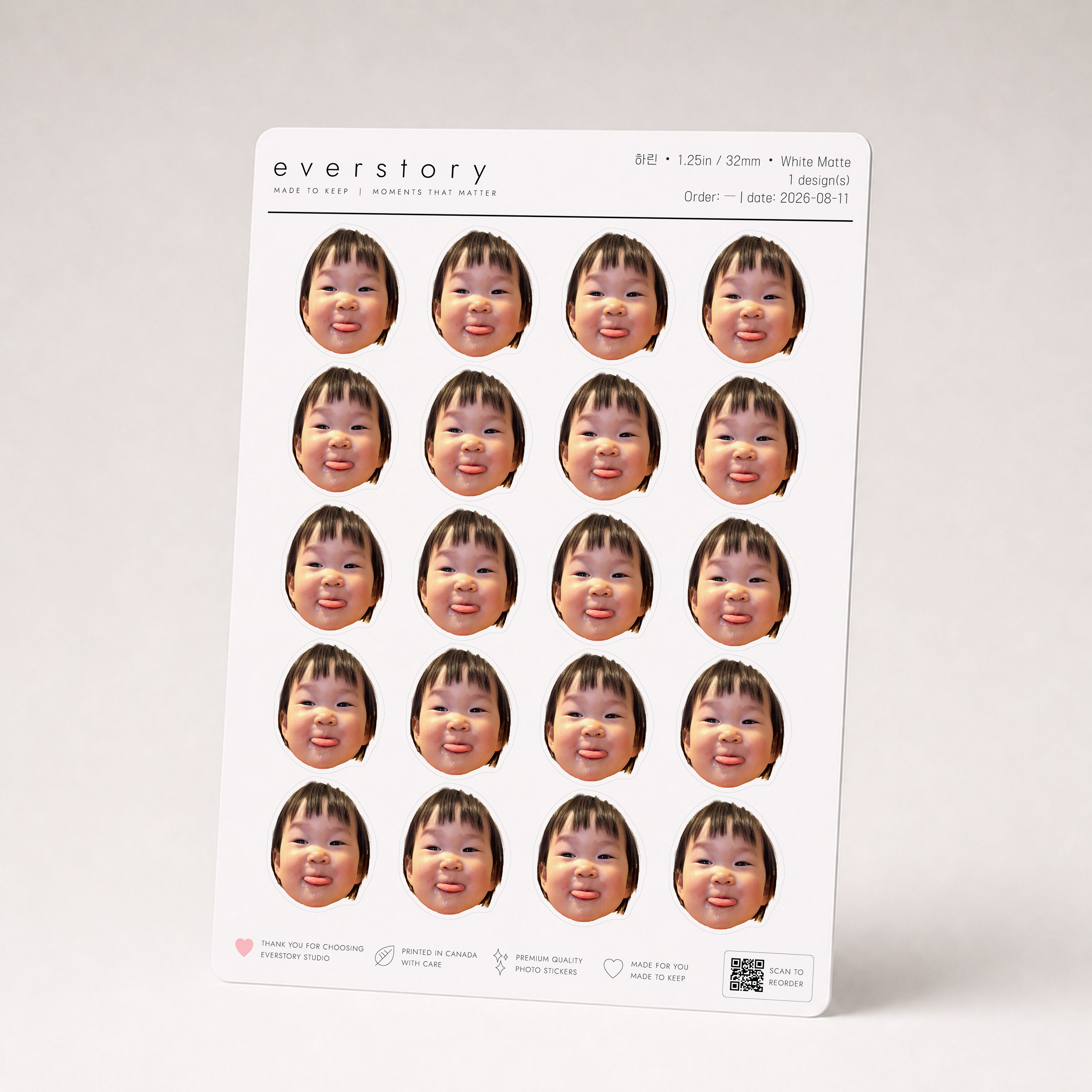 An A5 Everstory sheet standing upright, filled with twenty 1.25 inch face-cutout stickers of the same smiling toddler