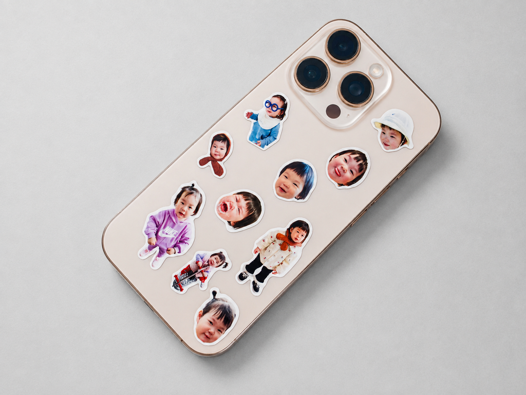 Die-cut face stickers of a toddler applied to the back of a phone