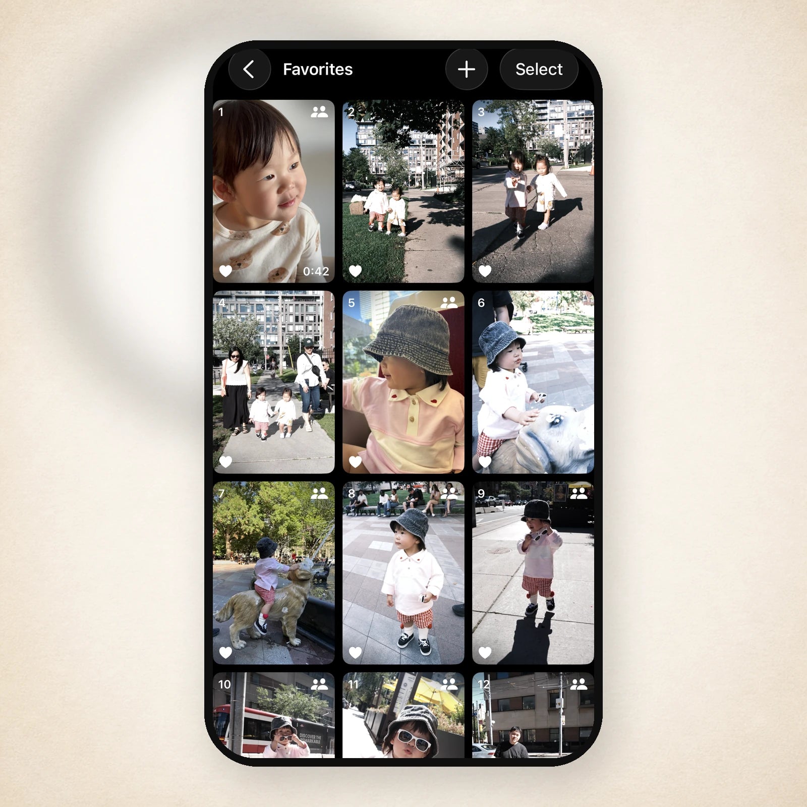 A phone showing a Favorites album of toddler photos, ready to pick favourites for a sticker sheet