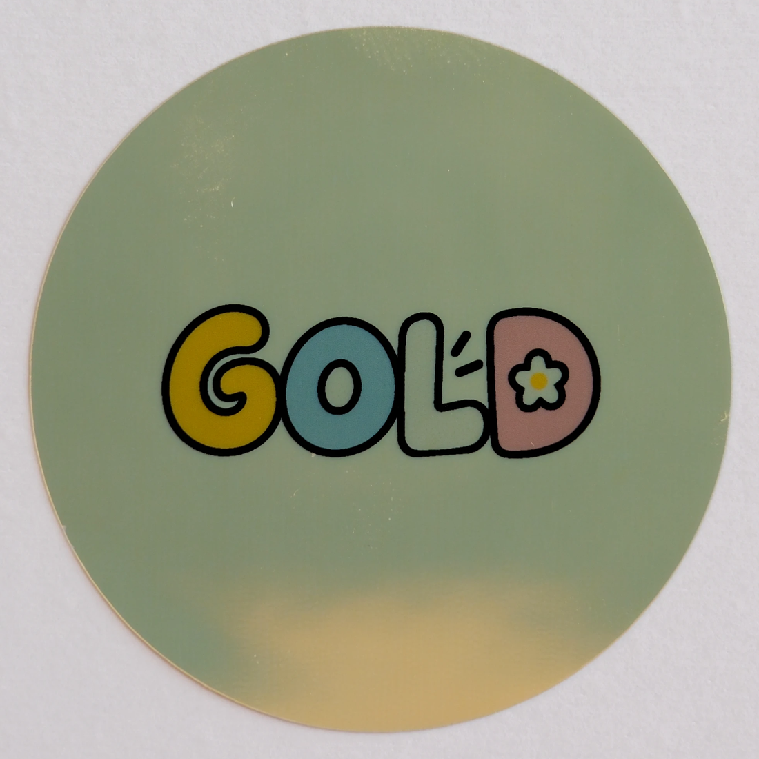 Gold sample: a round sticker printed with GOLD in bubble letters