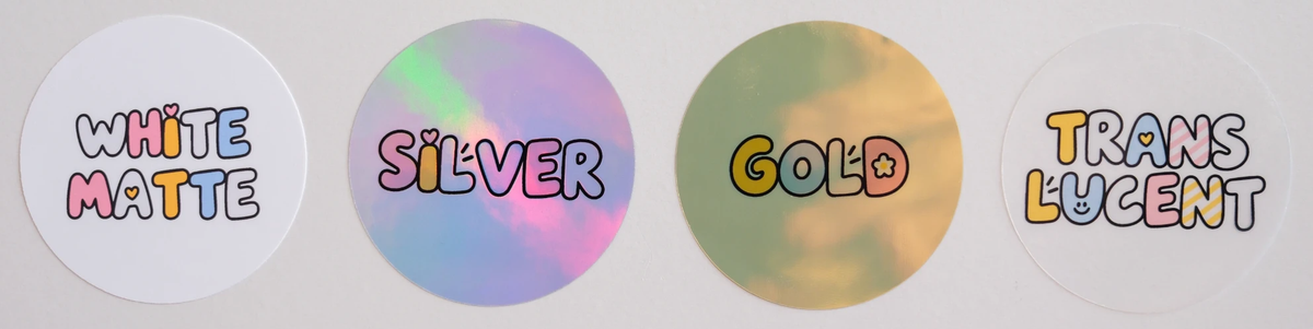Four round stickers, left to right: White Matte, Silver, Gold and Translucent, each printed with its material name